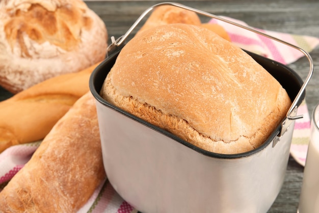 Bandeja de la máquina de pan con pan recién horneado en la mesa