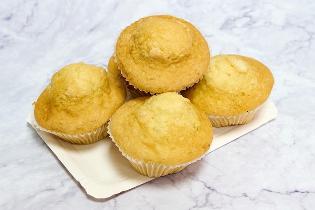 bandeja con muffins caseros sobre mesa de mármol