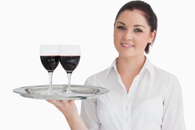 Bandeja de retención de mujer con vasos de vino tinto