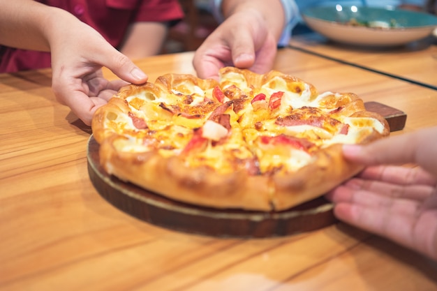 La bandeja de salsa de pizza caliente con ingredientes para pizza incluye jamón, cerdo, pimentón y verduras, pizza,