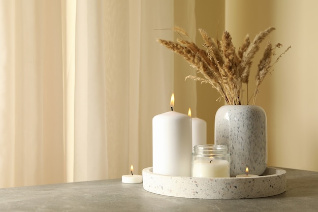 bandeja con velas perfumadas y caña en la mesa gris