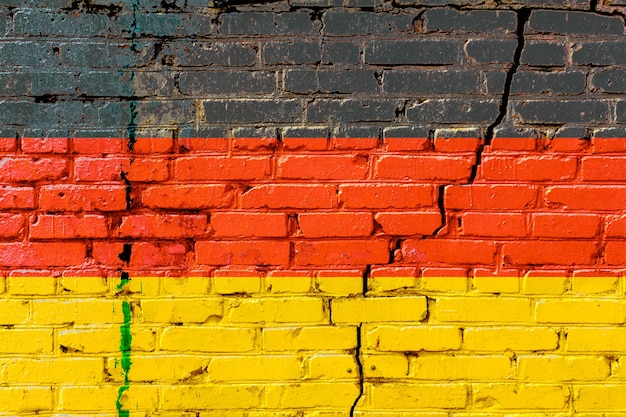 Bandera alemana pintada en una vieja pared de ladrillos