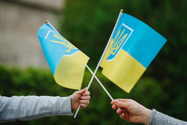 La bandera amarilla y azul ucraniana ondea en el viento al aire libre Mamá y niño sosteniendo la bandera en sus manos en la manifestación Símbolo nacional de libertad e independencia patriotismo Ninguna guerra detiene la agresión rusa