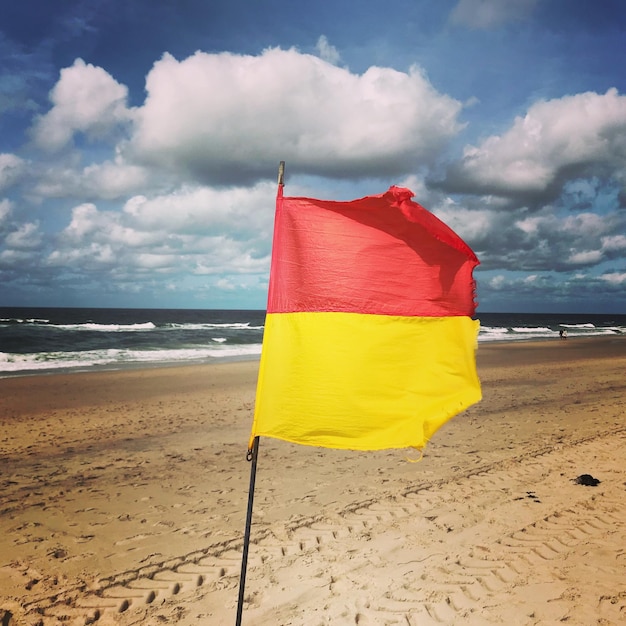 Foto bandera amarilla en la playa contra el cielo