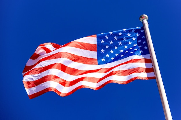 Bandera americana contra el cielo azul en el viento