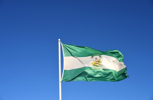 Foto bandera andaluza con un cielo azul