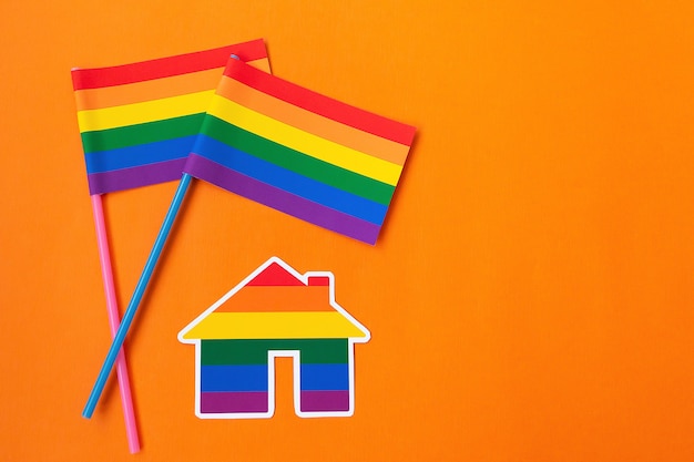 La bandera del arco iris y la casa, símbolo lgbt sobre un fondo naranja