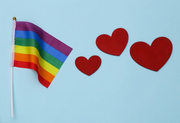 Bandera del arco iris LGBT y corazones sobre fondo azul. El amor no tiene género. Tolerancia, libertad
