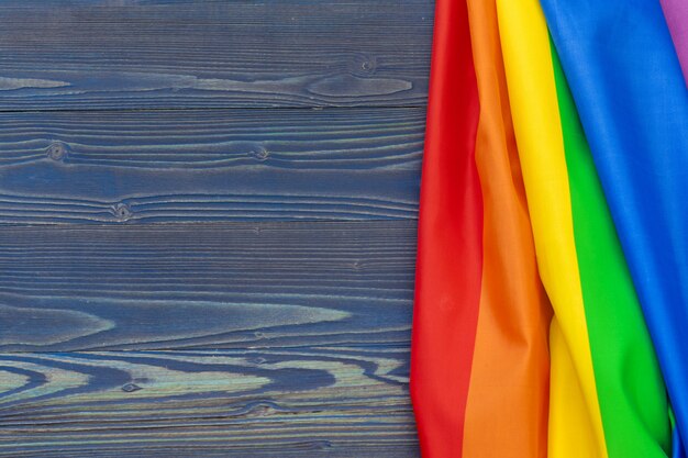 Bandera del arco iris lgbt sobre fondo de mesa de madera