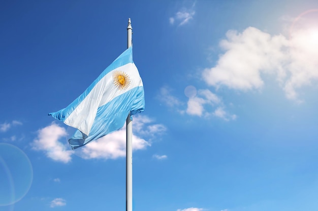 Bandera argentina ondeando en un cielo azul con espacio de copia