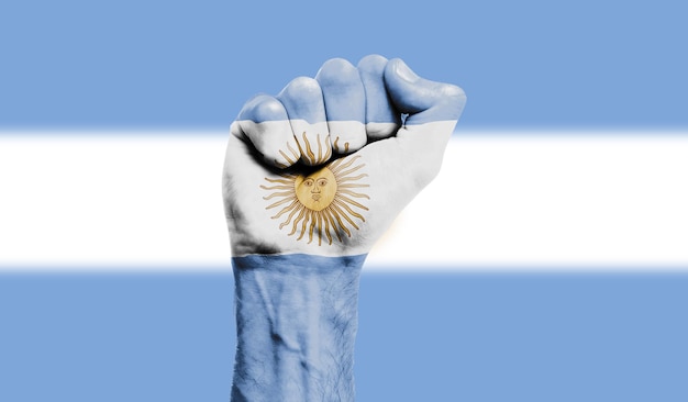 Foto bandera argentina pintada en un concepto de protesta de fuerza de puño cerrado