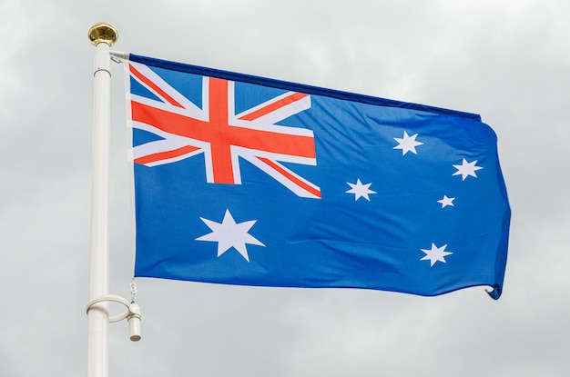 Bandera de Australia contra el cielo nublado blanco