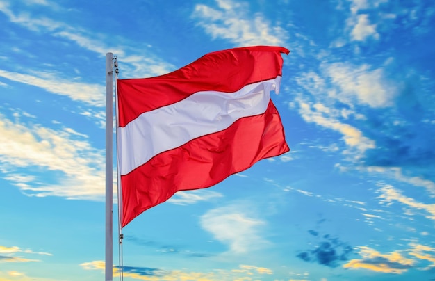 La bandera austriaca ondea en el poste sobre el hermoso cielo azul La independencia de Austria