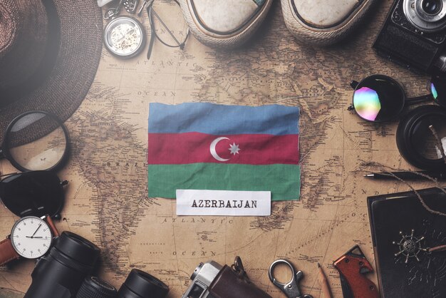 Bandera de Azerbaiyán entre los accesorios del viajero en el viejo mapa vintage. Tiro de arriba