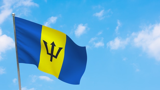 Bandera de Barbados en el poste. Cielo azul. Bandera nacional de barbados