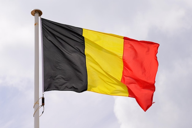 Bandera belga Estado nacional bandera de bélgica en alfombra de viento con cielo de nube azul