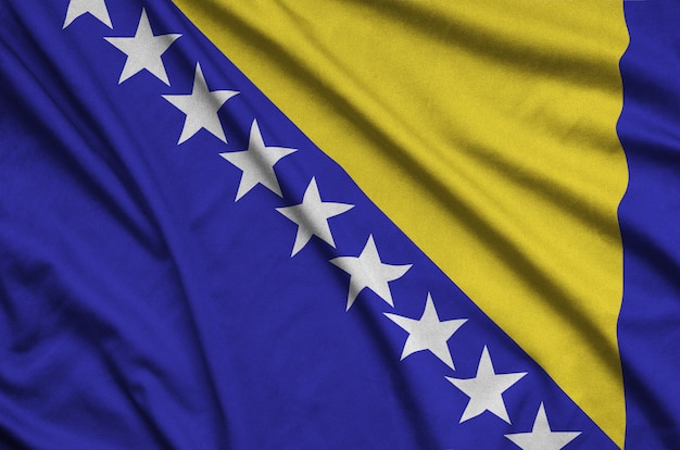 La bandera de Bosnia y Herzegovina está representada en una tela de tela deportiva con muchos pliegues.