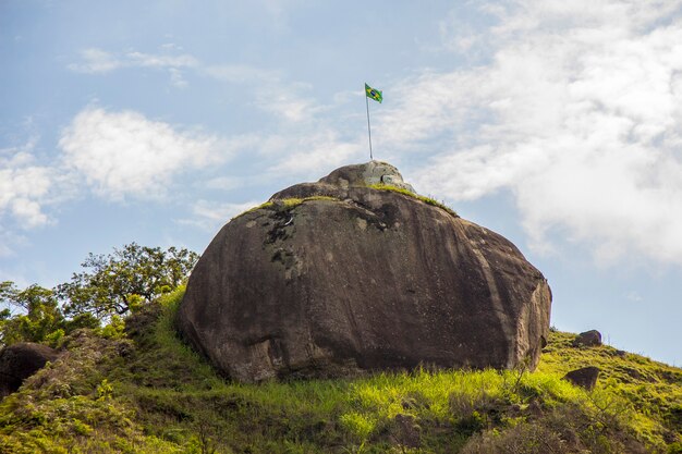 Bandera brasileña en la cima de una roca en Río de Janeiro, Brasil.