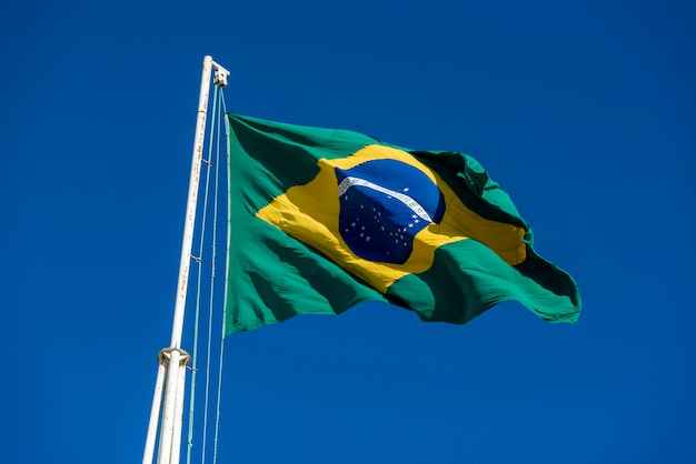 Bandera brasileña izada con cielo azul