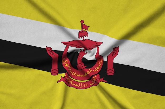 La bandera de Brunei Darussalam está representada en una tela de tela deportiva con muchos pliegues.