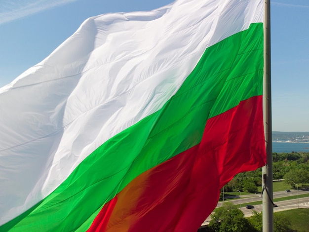 Bandera de Bulgaria contra la ciudad de Varna en el día de verano