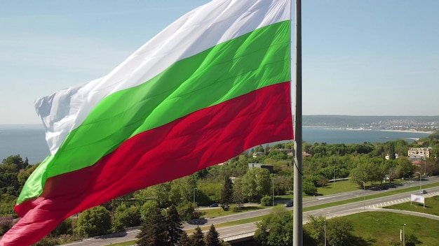 Bandera de Bulgaria contra la ciudad de Varna en el día de verano