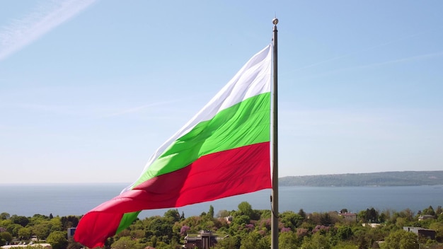 Bandera de Bulgaria contra la ciudad de Varna en el día de verano