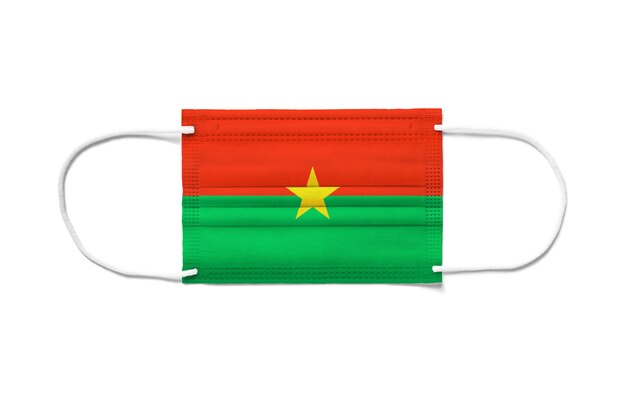 Bandera de Burkina Faso en una mascarilla quirúrgica desechable. Superficie blanca aislada