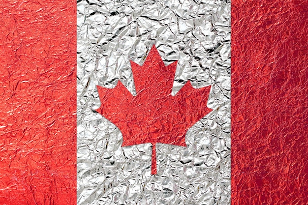 Bandera de Canadá con un fondo de textura de lámina de hoja brillante de bronce de hoja brillante