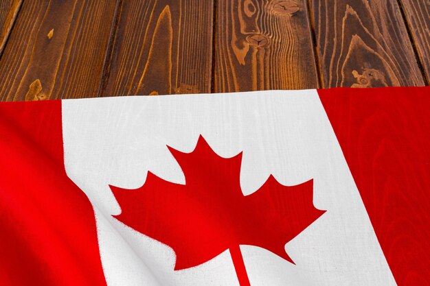 Bandera de Canadá sobre fondo de madera, espacio de copia