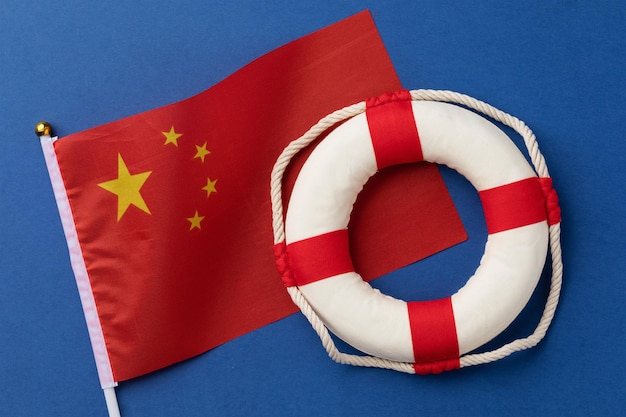 Bandera china y boya salvavidas en un fondo azul un concepto sobre el tema de la ayuda de China