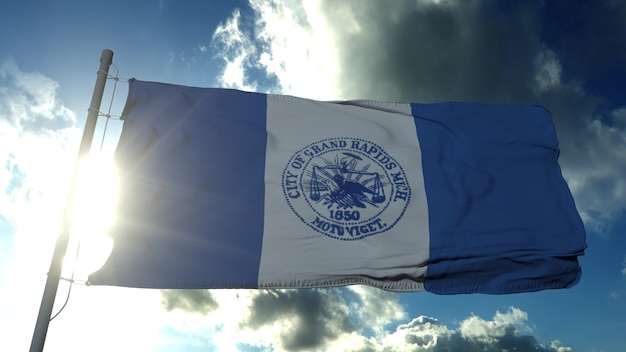 Foto bandera de la ciudad de grand rapids, ciudad de michigan, estados unidos de américa, ondeando al viento en el cielo azul. representación 3d