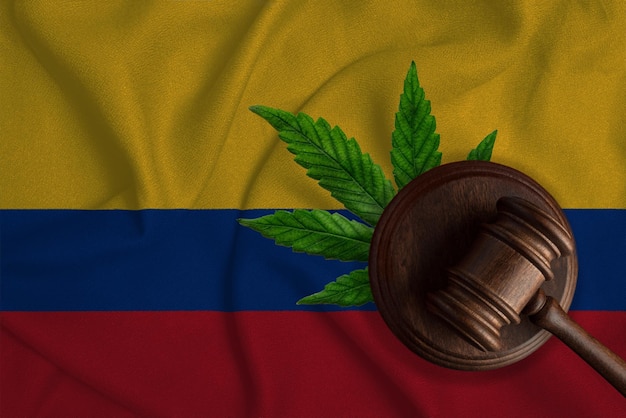 Bandera de Colombia y martillo de justicia con hoja de cannabis Cultivo ilegal de la planta de cannabis y propagación de drogas