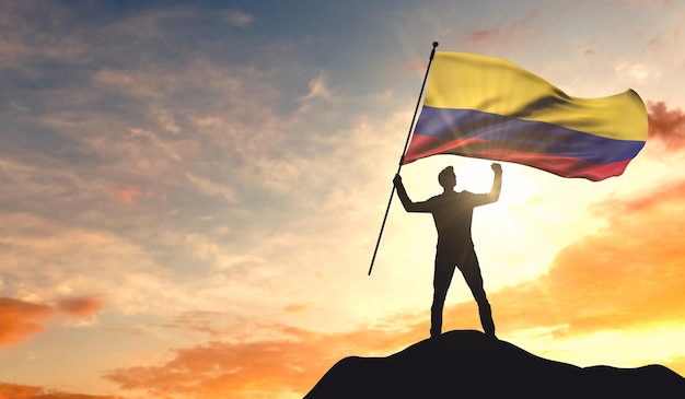 Bandera de Colombia ondeada por un hombre celebrando el éxito en la cima de una montaña 3D Rendering