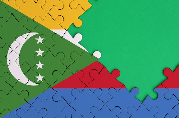 La bandera de las Comoras se representa en un rompecabezas completado con espacio libre de copia verde en el lado derecho