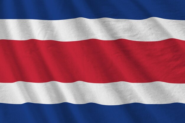 Bandera de Costa Rica con grandes pliegues ondeando de cerca bajo la luz del estudio en el interior Los símbolos y colores oficiales en la pancarta
