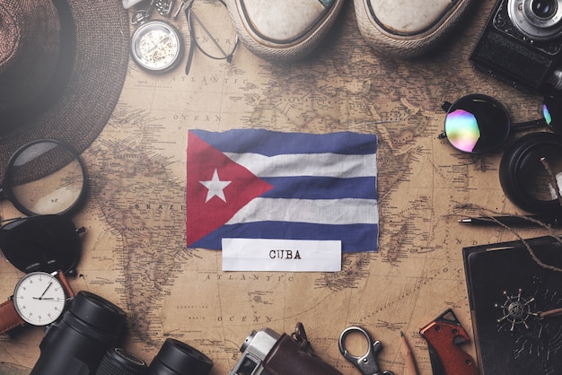 Bandera de Cuba entre los accesorios del viajero en el viejo mapa vintage. Tiro de arriba