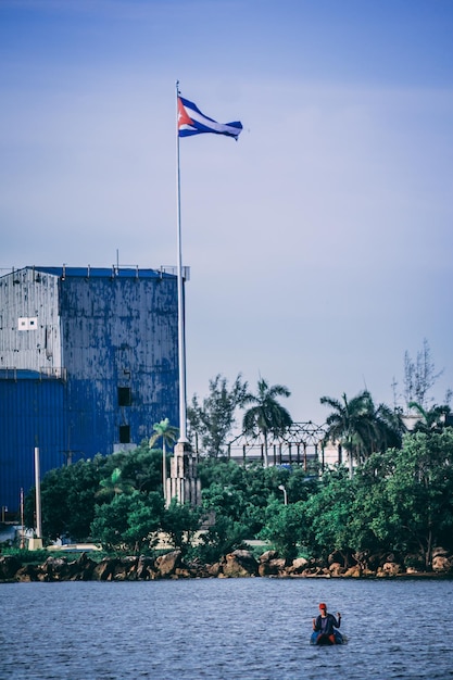 Bandera de Cuba cerca de edificios y estatuas junto al mar