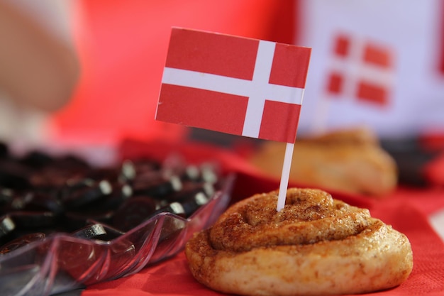 Foto una bandera danesa en una mesa con una bolsa de aceitunas negras