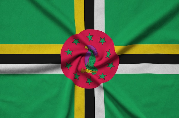 La bandera de Dominica está representada en una tela de tela deportiva con muchos pliegues.