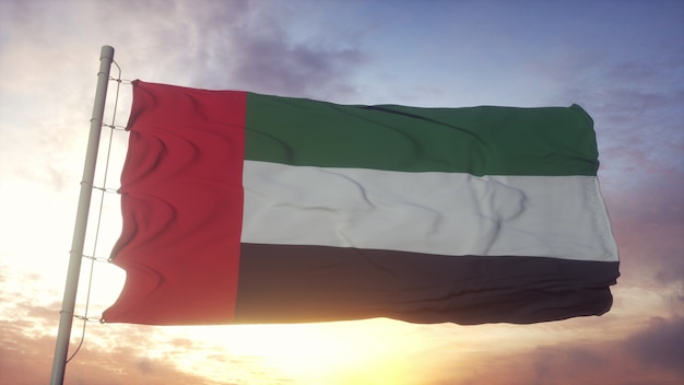 Bandera de los Emiratos Árabes Unidos ondeando en el viento contra el hermoso cielo profundo al atardecer. Representación 3D.