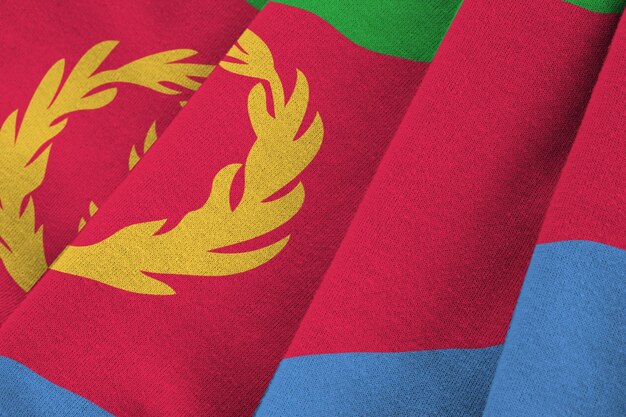 Bandera de Eritrea con grandes pliegues ondeando de cerca bajo la luz del estudio en el interior Los símbolos y colores oficiales en la pancarta