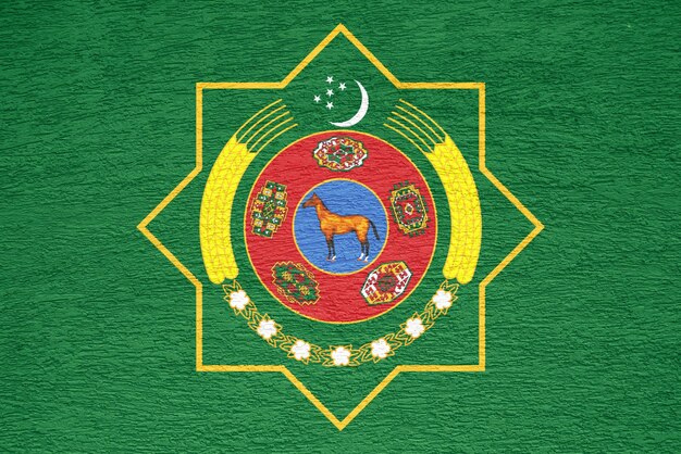 Foto bandera y escudo de armas de turkmenistán en un fondo texturizado collaje conceptual