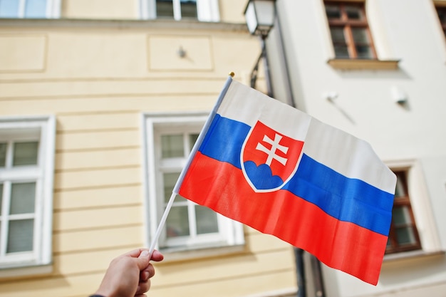 Bandera de Eslovaquia en mano contra la calle de Bratislava