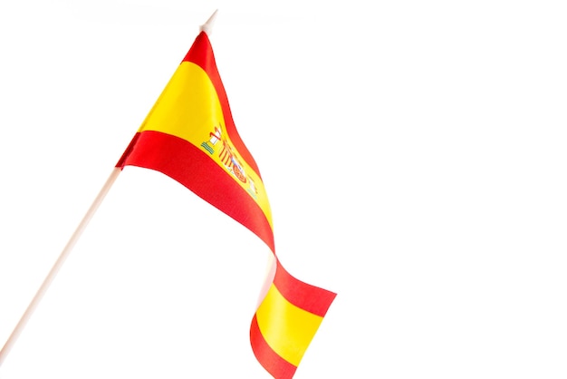 La bandera española sobre un fondo negro desarrollándose y revoloteando en el aislamiento del viento