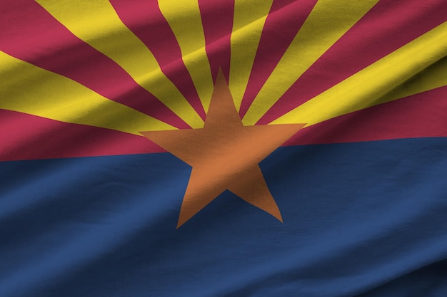 Bandera del estado de Arizona con grandes pliegues ondeando de cerca bajo la luz del estudio en el interior Los símbolos y colores oficiales en la pancarta
