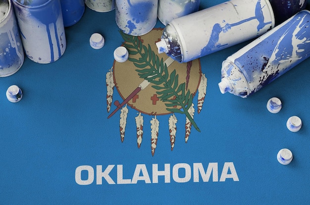Bandera del estado de Oklahoma, EE. UU. Y pocas latas de aerosol usadas para pintar graffiti arte callejero cultura conc