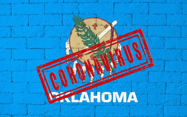 Bandera del estado de Oklahoma pintado sobre fondo de pared de ladrillo sucio. con sello CORONAVIRUS, idea y concepto de salud, epidemia y enfermedad en EE. UU.