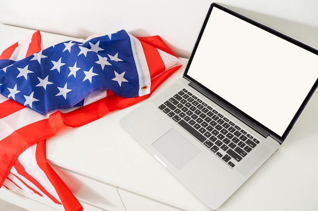 bandera de estados unidos el día de la independencia el 4 de julio, aislado en fondo blanco, detrás de una pantalla de pc de computadora vacía en blanco.