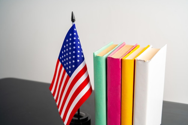 Bandera de los Estados Unidos con una pila de libros contra un fondo blanco